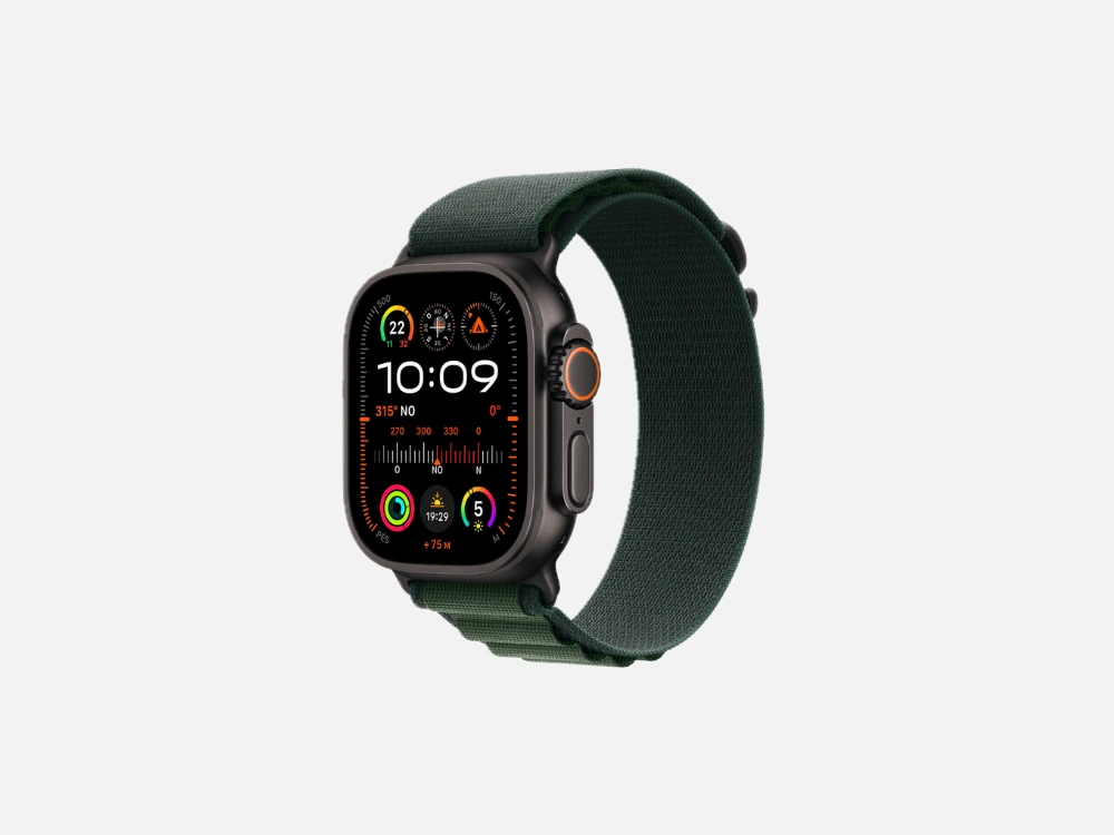 Imagem em fundo cinza do Apple Watch Ultra 2 com caixa em titânio escuro e pulseira de tecido verde (Loop Alpina). O visor deste smartwatch para corrida exibe a hora "10:09", uma bússola detalhada, anéis de atividade, elevação e outras métricas avançadas em cores vibrantes.