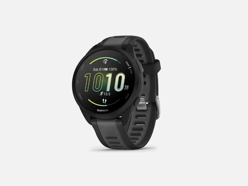 Imagem em fundo cinza de um Garmin Forerunner 165 preto. O visor circular deste smartwatch para corrida exibe a hora 10:10, bateria em 100% e métricas de passos, acompanhado por botões físicos laterais e uma pulseira esportiva de silicone texturizada.