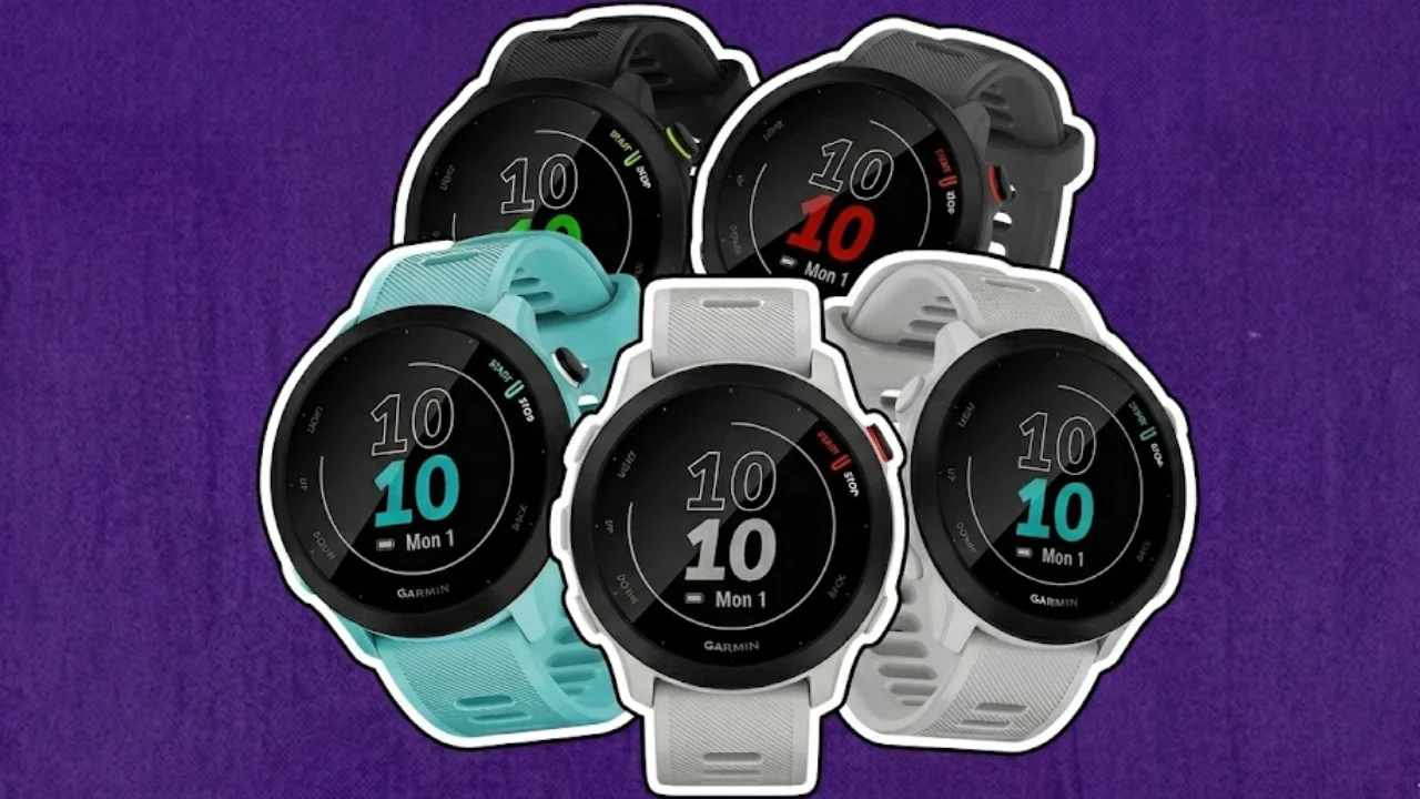 Montagem com quatro smartwatches Garmin Forerunner 55 em diferentes cores (preto, cinza, azul turquesa e branco) dispostos em leque sobre um fundo roxo texturizado. Os relógios possuem bordas brancas destacadas no estilo adesivo.