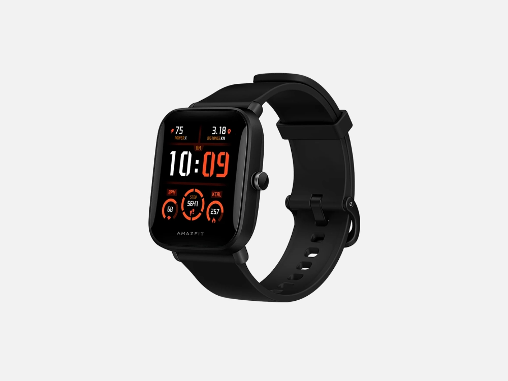 Imagem em fundo cinzo do relógio Amazfit Bip U Pro na cor preta. Este smartwatch para corrida exibe uma tela quadrada com um mostrador de fundo camuflado verde, ponteiros analógicos e métricas de treino, acompanhado por uma pulseira de silicone.