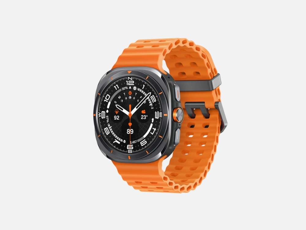 Vista em ângulo do smartwatch à prova d'água Samsung Galaxy Watch Ultra em cinza com uma pulseira esportiva laranja texturizada.