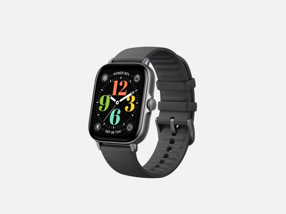 Um smartwatch preto com formato quadrado e cantos arredondados está centralizado sobre um fundo cinza claro. A tela está ligada, exibindo um mostrador de horas colorido com os números grandes e vibrantes: 12 (vermelho), 3 (amarelo), 6 (azul-esverdeado) e 9 (verde). Ponteiros brancos finos indicam o horário. Acima do 12, lê-se "POWER 80%". Abaixo do 6, consta "SEP 08 THU" (8 de setembro, quinta-feira). O dispositivo possui uma caixa metálica escura e uma pulseira de silicone preta texturizada com fivela e passadores pretos, posicionada em um ângulo que mostra a parte frontal e lateral direita com a coroa rotativa.
